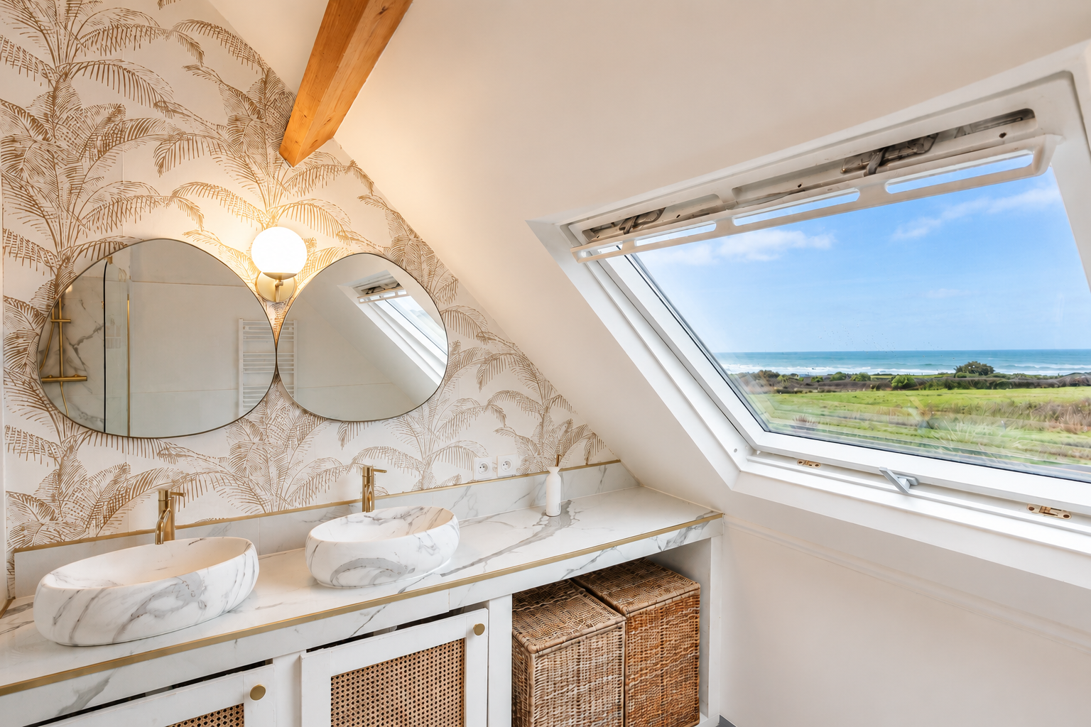 Grande salle de bain avec double vasque en marbre et fenêtre sur la mer